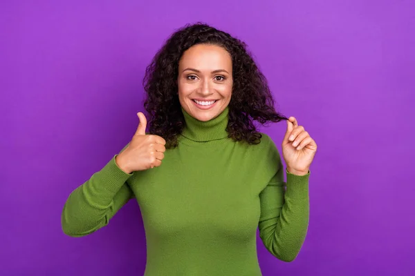 Foto de mulher afro muito brilhante usar gola alta verde mostrando polegar para cima segurando mão braço curl sorrindo isolado cor roxa fundo — Fotografia de Stock
