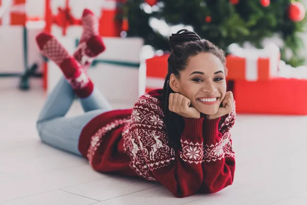 Retrato de menina alegre atraente deitado no tapete jumper feio desfrutando de clima de dia festivo em casa branca clara dentro de casa — Fotografia de Stock