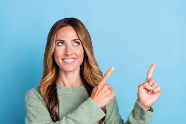 Foto retrato mulher sorrindo sonhador apontando dedo espaço em branco isolado pastel azul cor fundo — Fotografia de Stock