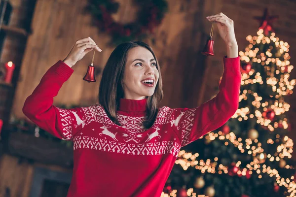Foto de encantador sonhador jovem mulher vestida camisola vermelha pendurado ano novo bolas sorrindo dentro de casa quarto casa — Fotografia de Stock