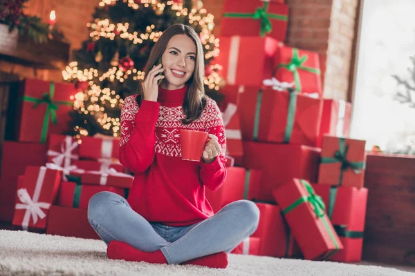Fotografie pozitivní přátelský společenský dáma sedící na podlaze telefon vychutnat ranní kávu v dekorované x-mas doma uvnitř — Stock fotografie