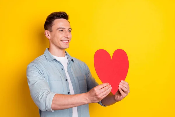 Profil Seitenansicht Porträt von attraktiven verliebten fröhlichen Kerl geben Herz isoliert über helle gelbe Farbe Hintergrund — Stockfoto