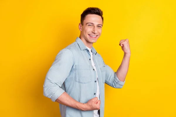 Foto von jungen fröhlich lächelnden gutaussehenden Mann heben die Fäuste in Sieg gewinnen Preis glücklich isoliert auf gelbem Hintergrund hell — Stockfoto