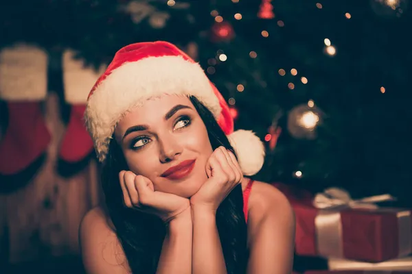 Foto de sonho inspirado jovem menina mãos rosto olhar para cima acho que imaginar usar santa xmas headwear dentro de casa — Fotografia de Stock