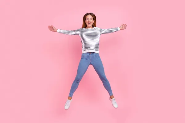 Foto von süßen entzückende junge Frau gekleidet gestreiften Pullover springen hoch wie Sterne isoliert rosa Hintergrund — Stockfoto