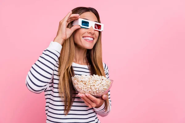 Photo of charming cute mature lady wear striped sweater cyber glasses eating popcorn looking empty space isolated pink color background — Stock Photo, Image