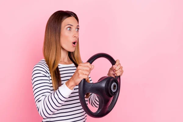 印象的な若い女性の服を着たストライププルオーバー空のスペース孤立ピンク色の背景を見て車を運転 — ストック写真