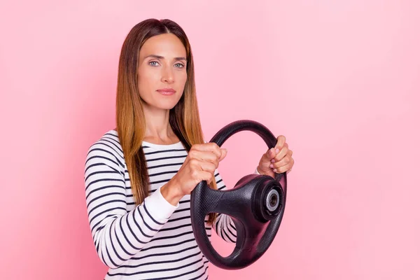 Foto de señora madura con confianza seria usar suéter a rayas que sostiene el volante aislado de color rosa fondo —  Fotos de Stock