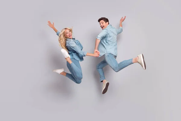 Retour photo pleine grandeur de couple cool saut porter jeans chemise chaussures isolé sur fond de couleur grise — Photo