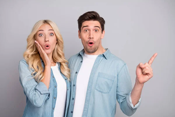 Foto av unga par förvånad chock omg visar fingrarna tomt utrymme annonsera promo isolerad över grå färg bakgrund — Stockfoto