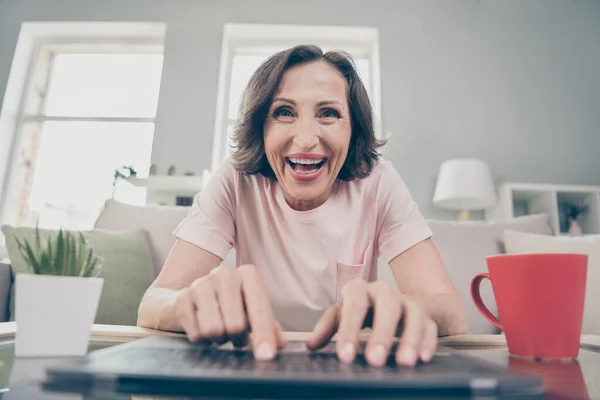 Fotografie staré brunetky legrační dáma typ notebook nosit růžové tričko doma sám — Stock fotografie