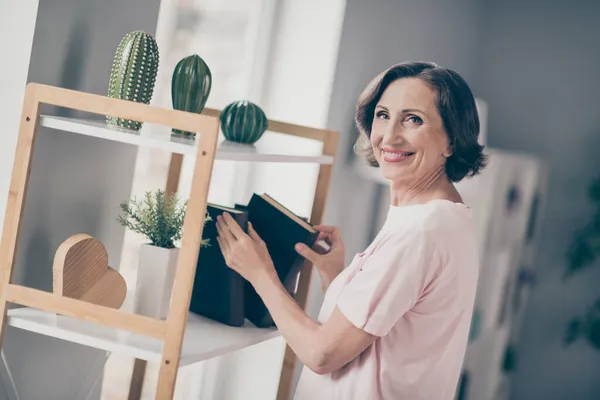 Profiel foto van volwassen schattig brunette dame houden boek dragen roze t-shirt alleen thuis — Stockfoto