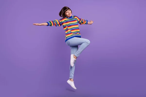 Foto de inspiração senhora salto desfrutar avião pose voo desgaste listrado camisola jeans calçado isolado roxo cor fundo — Fotografia de Stock
