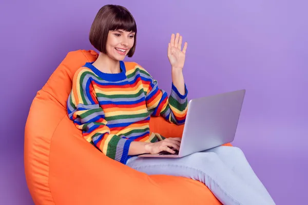 Foto del programador de distancia lady sit beanbag ola mano video llamada desgaste suéter rayado aislado color púrpura fondo — Foto de Stock