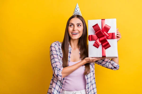 Foto de mujer joven feliz sonrisa positiva agitar curioso recibir regalo aislado sobre fondo de color amarillo —  Fotos de Stock