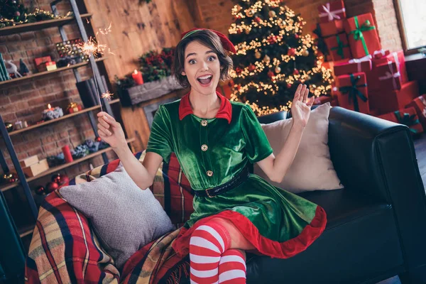 Foto de sorprendido sorprendido alegre mujer santa helper sentarse sofá navidad humor espíritu chispeante dentro de casa casa — Foto de Stock