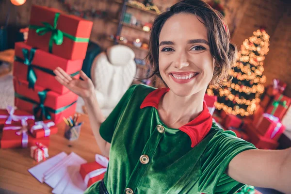 Foto de blogger lady tomar selfie demostrar bienvenida pila regalos usar traje de elfo en la oficina decorada en interiores —  Fotos de Stock