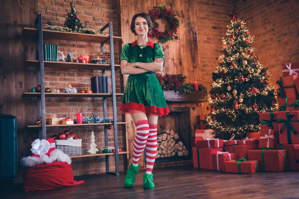 Teljes test fotó a fiatal boldog pozitív Mikulás segítő nő karácsonyi hagyomány kéz keresztbe beltéri házon belül otthon — Stock Fotó