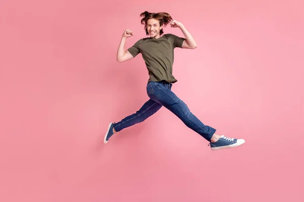 Full size profil boczny zdjęcie młodego faceta szczęśliwy pozytywny uśmiech skok bieg świętować sukces zwycięzca odizolowany ponad różowy kolor tła — Zdjęcie stockowe