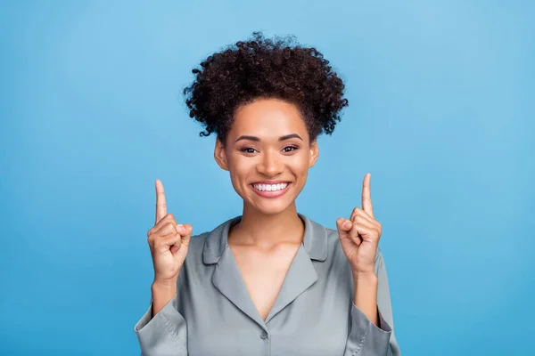 Photo of young african girl good mood indicate fingers empty space advice choose suggest isolated over blue color background — Stock Photo, Image