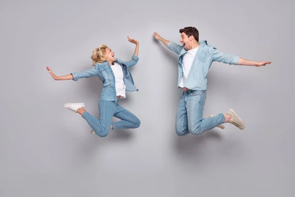 Tamanho do corpo de comprimento total vista de casal alegre atraente pulando ter passatempo divertido isolado sobre fundo de cor pastel cinza — Fotografia de Stock