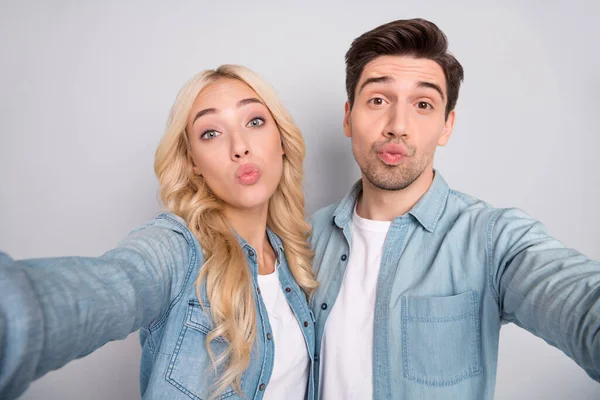 Foto de casal muito charmoso jovem vestido jeans camisas tacking selfie enviando-lhe beijo isolado fundo de cor cinza — Fotografia de Stock