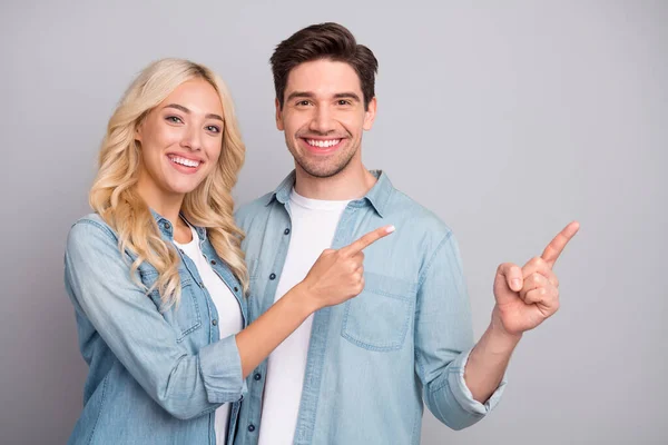 Foto di giovane coppia felice sorriso positivo indicano dita spazio vuoto annuncio promo suggeriscono isolato su sfondo di colore grigio — Foto Stock