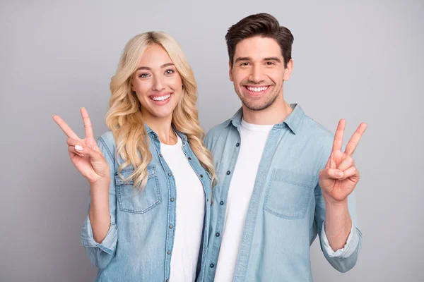 Retrato de atraente alegre abraço casal afetuoso mostrando v-sinal isolado sobre fundo cor pastel cinza — Fotografia de Stock