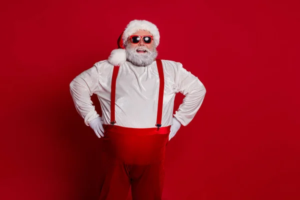 Foto di fiducioso positivo allegro sovrappeso uomo mani fianchi indossare costume di Babbo Natale isolato colore rosso sfondo — Foto Stock