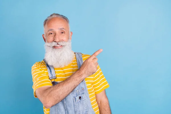 Foto de hombre gris viejo divertido punto espacio vacío desgaste camiseta amarilla en general aislado sobre fondo de color azul — Foto de Stock