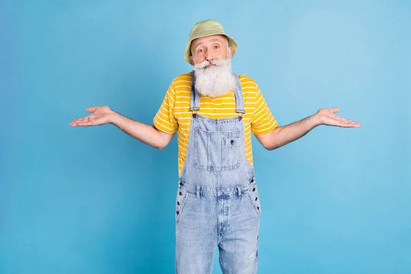 Fénykép a szomorú kor fehér szakáll férfi vonós vállak viselni sapka sárga póló összességében elszigetelt kék színű háttér — Stock Fotó