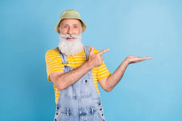 Foto de hombre mayor feliz sonrisa positiva dedo dedo producto promo publicidad sugieren aislado sobre fondo de color azul — Foto de Stock