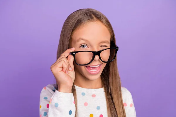 Foto av roliga nörd liten dam blinka öga slitage glasögon prickade pyjamas isolerad lila färg bakgrund — Stockfoto