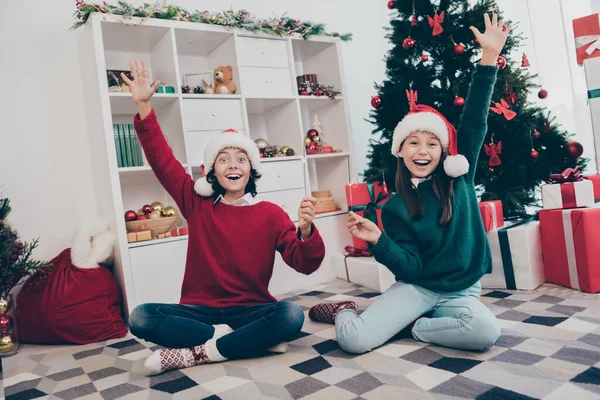 Foto de duas crianças animadas segurar fogo bengala x-mas parabéns conceito usar chapéu jumper em casa decorada dentro de casa — Fotografia de Stock
