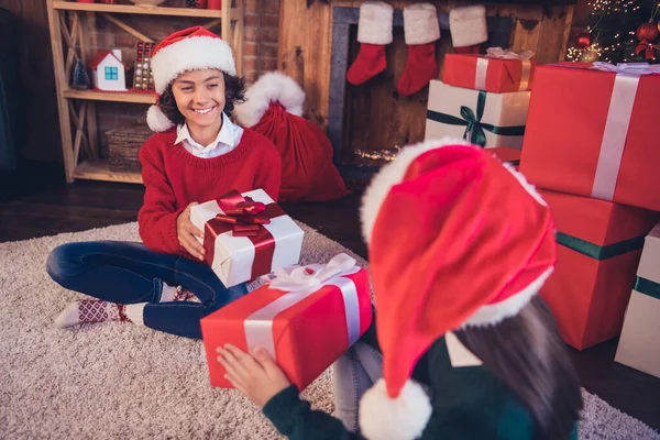 Retrato de irmãos alegres atraentes Papai Noel ajudantes dando troca de caixas de presente tempo do evento em casa interior loft decorado dentro de casa — Fotografia de Stock