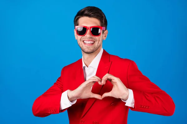 Foto de jovem bonito homem feliz sorriso positivo mostrar dedo coração símbolo amor romance isolado sobre azul cor fundo — Fotografia de Stock