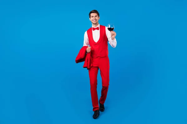 Full length photo of young guy happy positive smile go walk hold glass wine drink three-piece isolated over blue color background — Stock Photo, Image