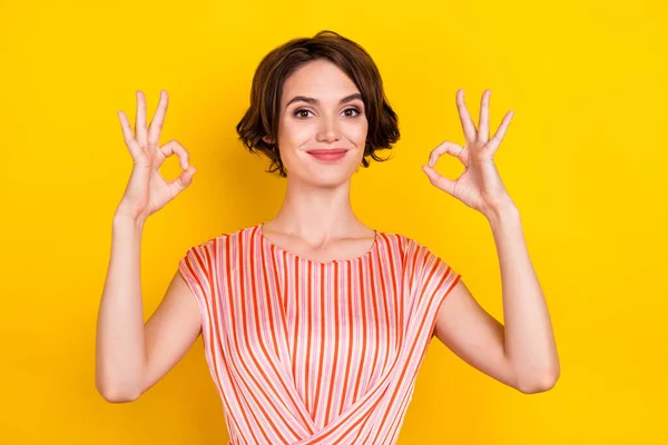 Portrait of attractive cheerful girl showing double ok-sign ad solution isolated over bright yellow color background — Stock Photo, Image