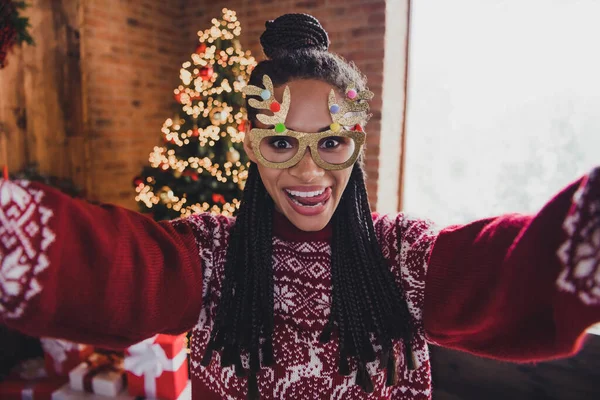 Φωτογραφία από αστεία κυρία influencer λάβει x-mas selfie δείχνουν γλώσσα φορούν ελάφια γυαλιά jumper σε διακοσμημένο σπίτι σε εσωτερικούς χώρους — Φωτογραφία Αρχείου