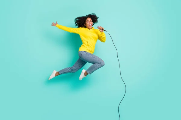 フル長さボディサイズ写真女性ジャンプアップ歌でマイク隔離された明るいティール色の背景 — ストック写真