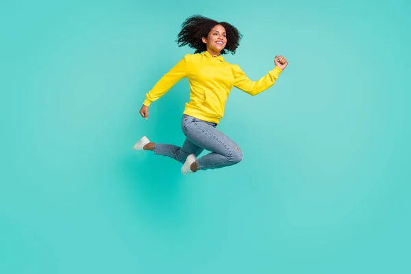 밝은 청록색 배경 위로 분리되어 달리고 있는 활기찬 소녀의 전체 몸길이 전망 — 스톡 사진