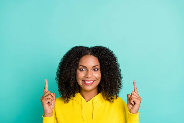 Foto retrato encaracolado mulher mostrando espaço vazio sorrindo isolado brilhante cor teal fundo — Fotografia de Stock