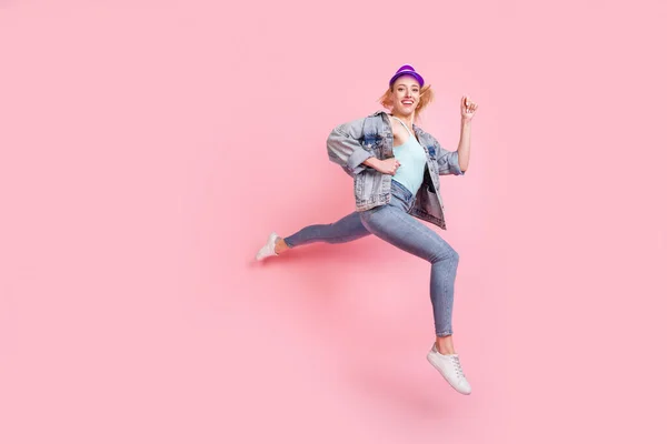 Profilo full size foto di impressionato bionda millenaria signora correre indossare jeans giacca visiera isolato su sfondo rosa — Foto Stock