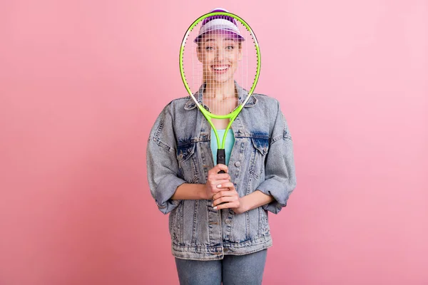 Портрет привлекательной веселой девушки, скрывающейся за ракеткой, одурачивающей розовый пастельный фон — стоковое фото