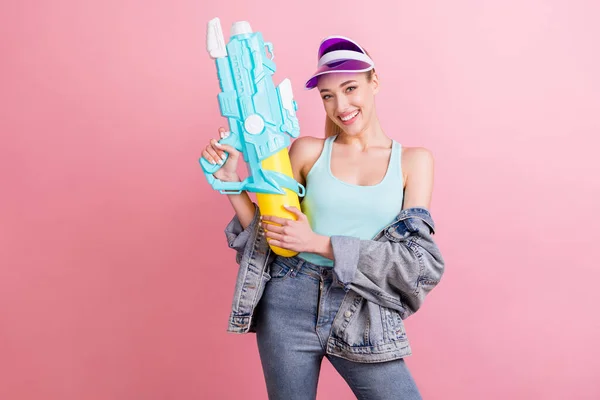 Foto von lustigen blonden jungen Dame mit Waffe tragen blaues Top Jacke Visier isoliert auf rosa Hintergrund — Stockfoto