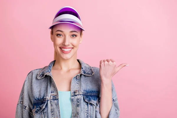 Foto de la cola amigable peinado joven mujer activa punto vacío espacio usar jeans camisa sombrero aislado sobre fondo de color rosa —  Fotos de Stock