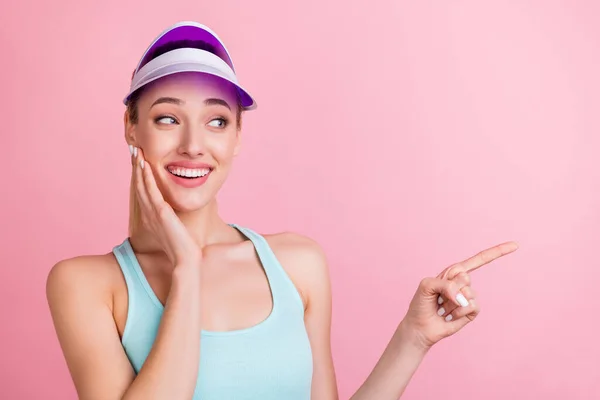 Photo of impressed shiny young woman dressed teal singlet arm cheek pointing finger empty space isolated pink color background — Stock Photo, Image