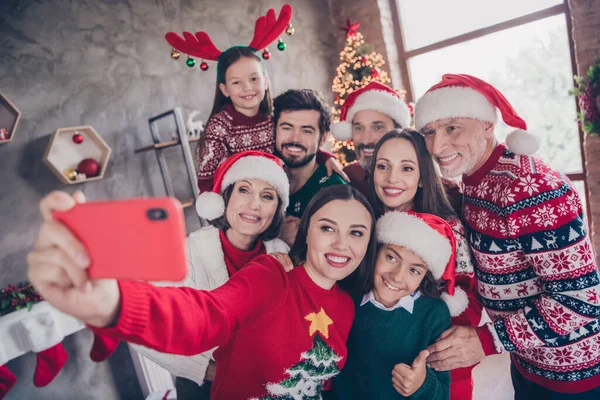 Большая семья делает селфи, улыбаясь в праздничном наряде на Рождество в украшенной квартире — стоковое фото