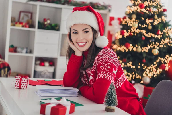 Fotografie mladé krásné dívky dokončit psaní pohlednice zbytek těšit vánočních svátků nosit Santa Claus klobouk uvnitř — Stock fotografie