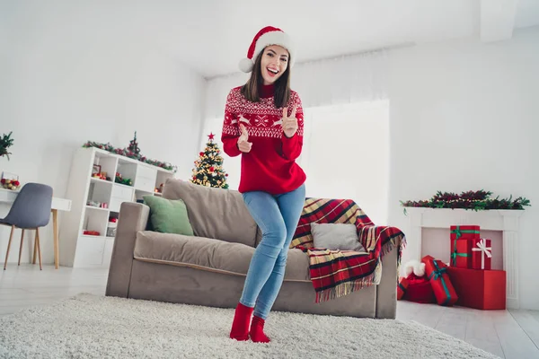 Pleine taille photo de jeune fille joyeuse avoir du plaisir indiquer doigts cool ad choix costume de Noël à l'intérieur — Photo
